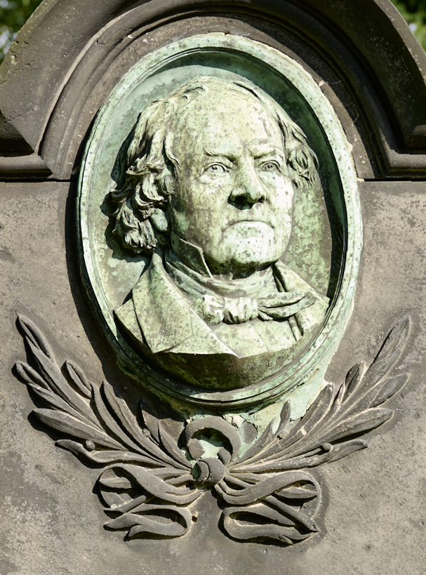 Bildtitel - Nahaufnahme des Bronzereliefs mit dem Porträt von Adam Heinrich Junkermann.